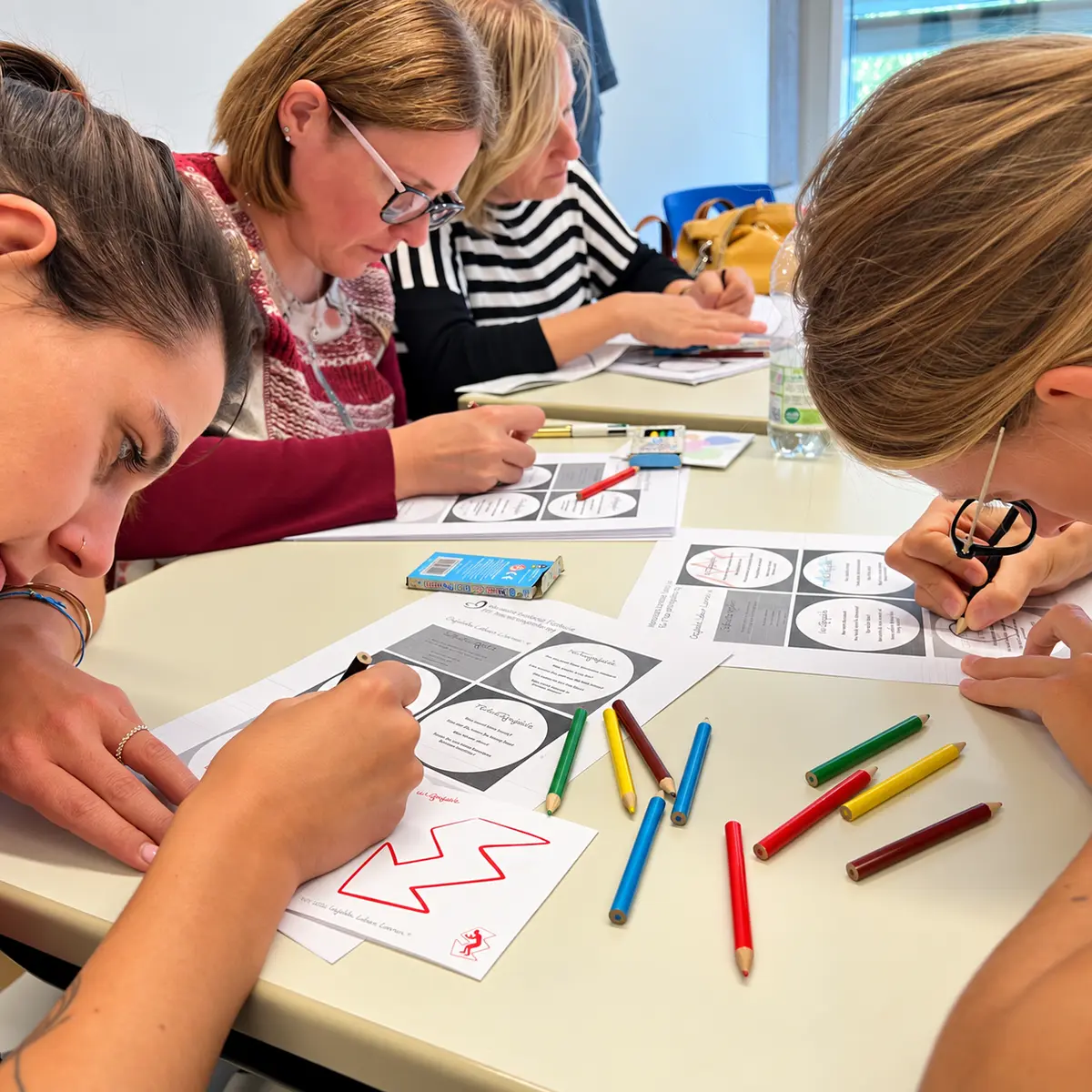 Teilnehmerinnen arbeiten gemeinsam mit Gefühlsformen und Arbeitsblättern des Modells GEFÜHLE.LEBEN.LERNEN.®.